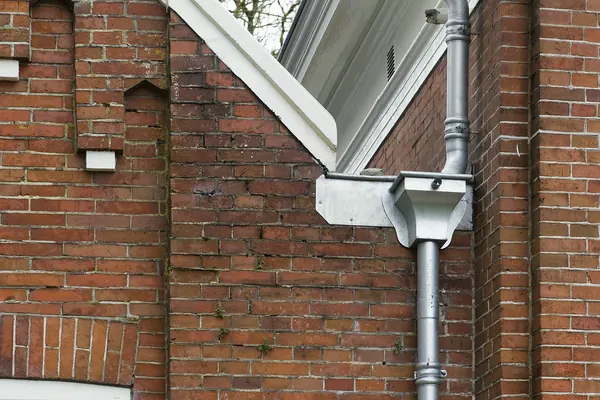 Zinken regenpijp met vergaarbak onder de dakrand, dakgoten in Amsterdam