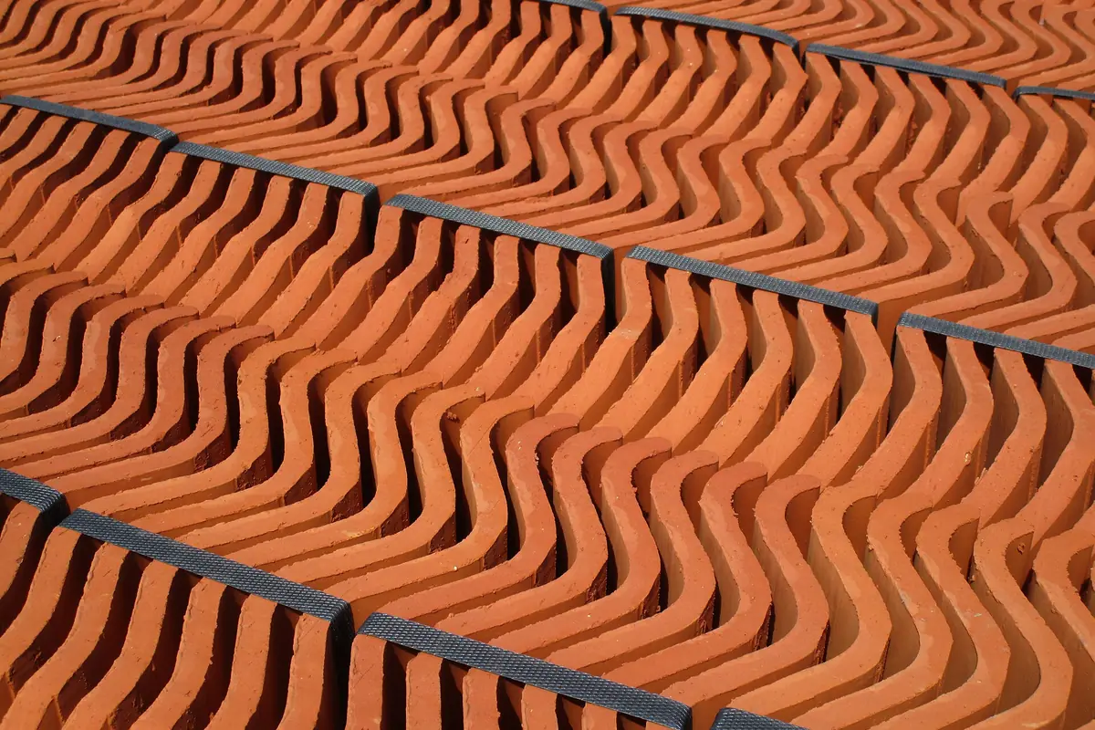 Rijen oranje keramische dakpannen in een krat, materiaal dat meetelt in de kosten van dakwerken in Amsterdam